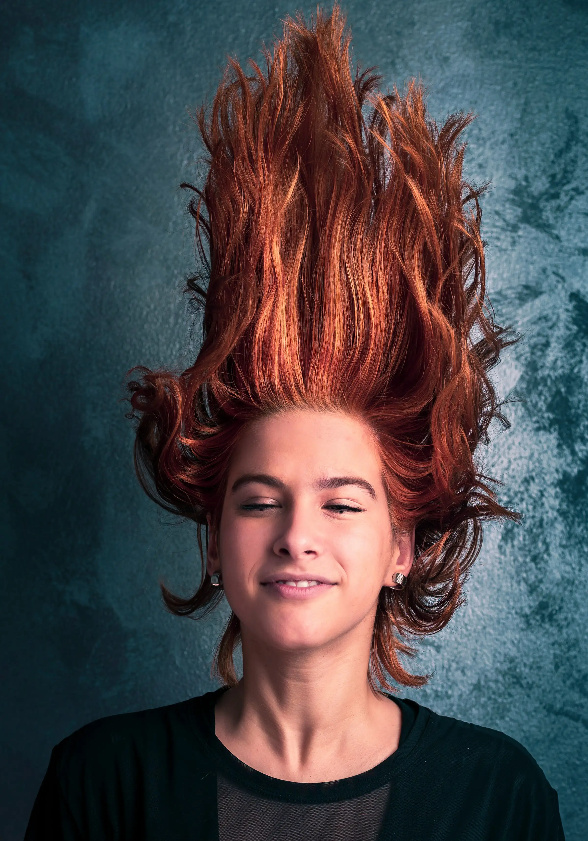 A woman lying back with her copper-red hair fanned out above her head